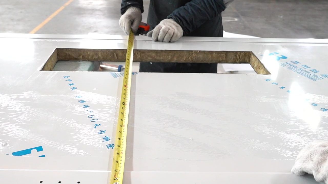 Worker measuring industrial door dimensions during installation